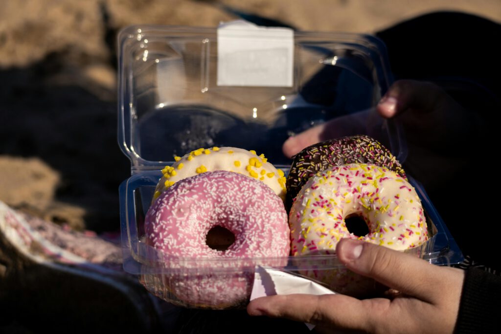 Värikkäitä donitseja läpinäkyvässä muovirasiassa