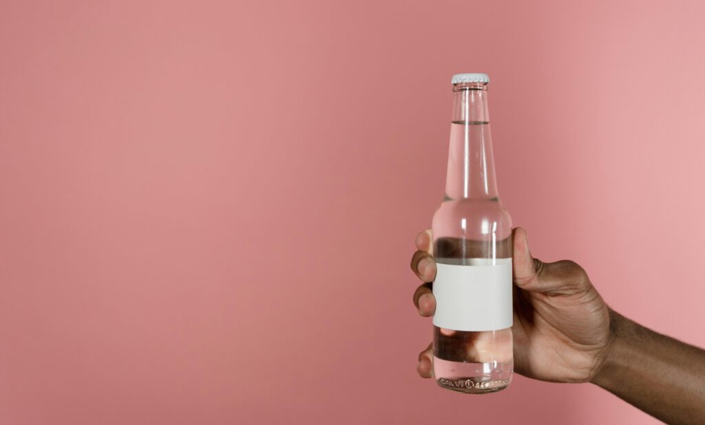 minimalistisen lasipullon pakkausdesign pinkillä taustalla